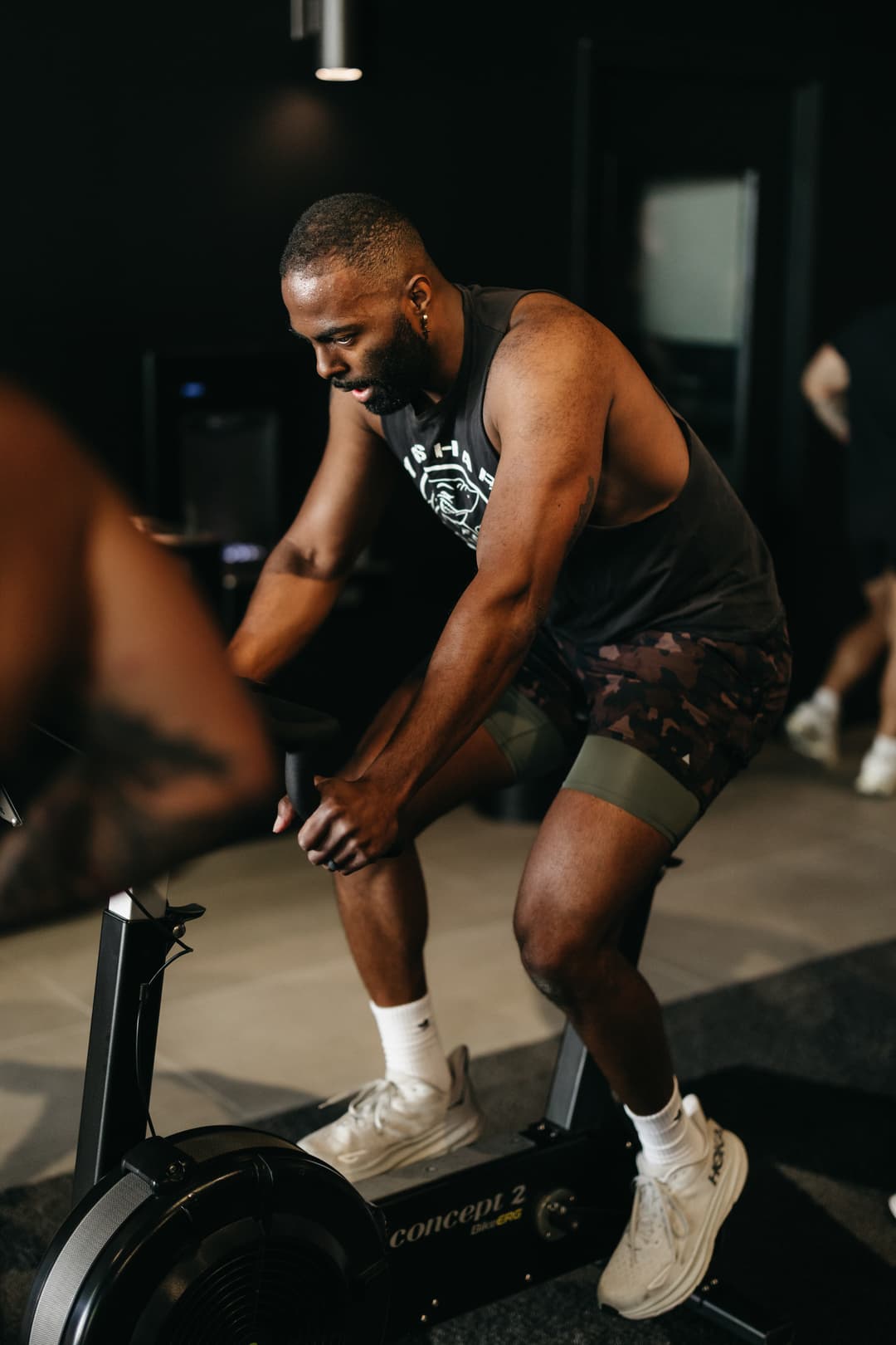 Conditioning session in progress with a member pushing through intervals on the bike erg.